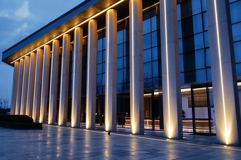Commercial building facade lighting with LED wall washer lights illuminating columns at night